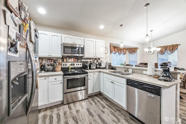 kitchen with white cabinetry, stainless steel appliances, sink, and hanging light fixtures