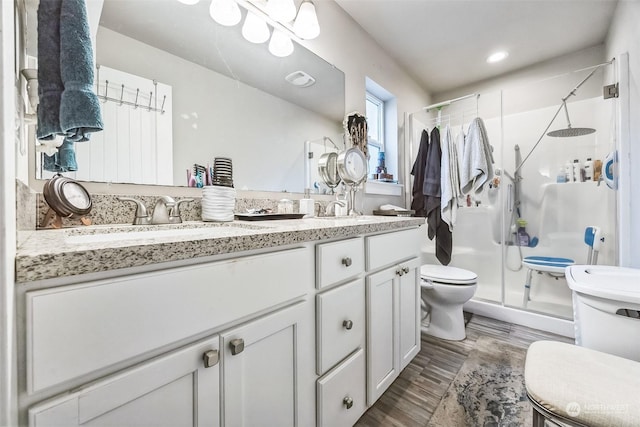 bathroom with walk in shower, wood-type flooring, toilet, and vanity