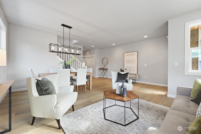 living room featuring light hardwood / wood-style flooring and an inviting chandelier