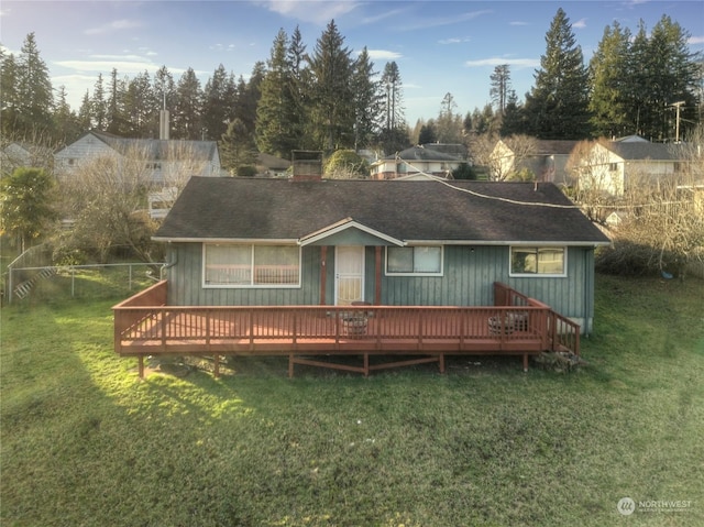 rear view of house with a lawn and a deck