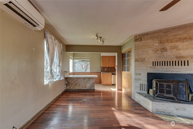 unfurnished living room featuring dark wood-type flooring and a wall unit AC