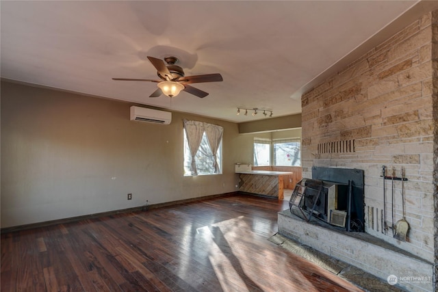 unfurnished living room featuring track lighting, ceiling fan, dark hardwood / wood-style floors, and a wall mounted AC