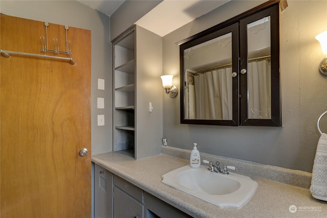 bathroom featuring built in shelves, vanity, and a shower with shower curtain