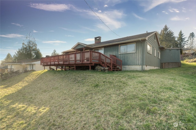 rear view of property with a deck and a lawn