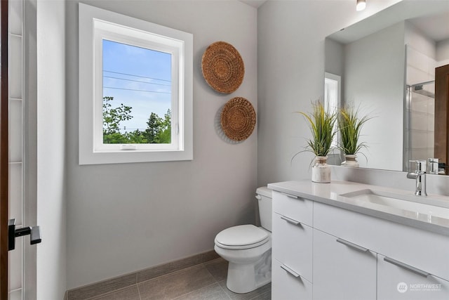 bathroom with vanity, toilet, and a shower with door