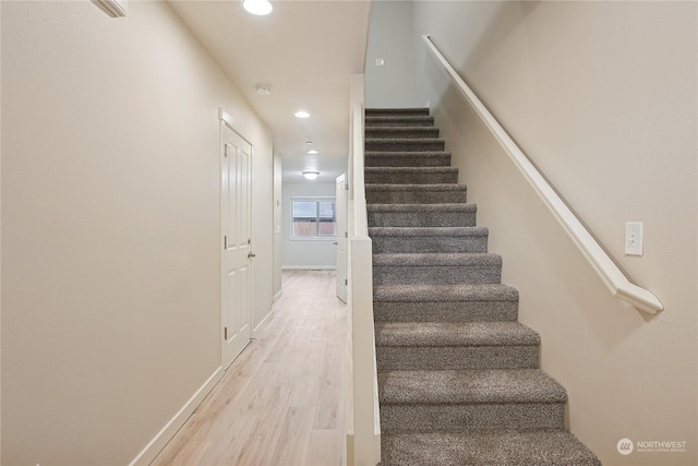 staircase with hardwood / wood-style flooring