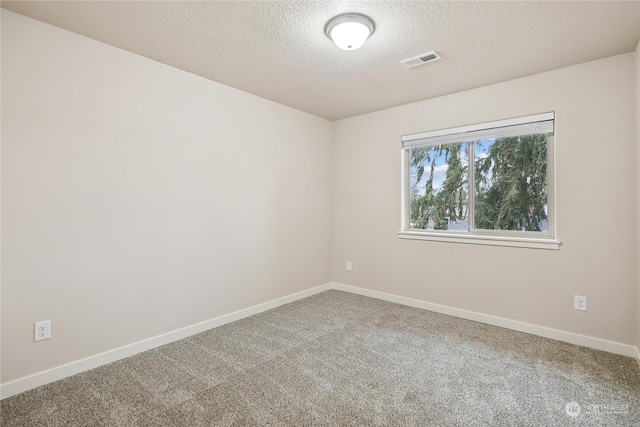 carpeted spare room with a textured ceiling