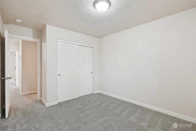 unfurnished bedroom with a closet, carpet, and a textured ceiling