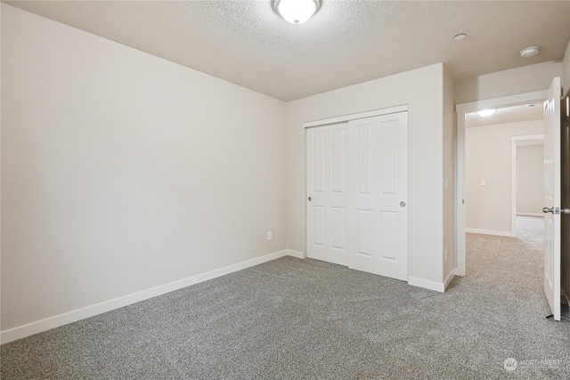 unfurnished bedroom with carpet, a textured ceiling, and a closet