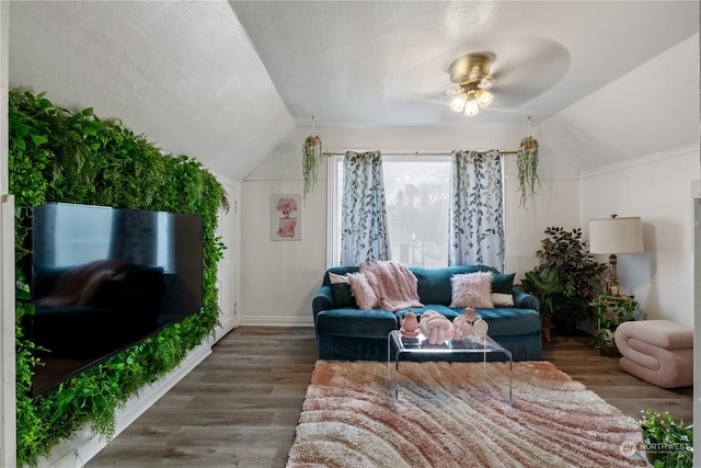 living room with vaulted ceiling, ceiling fan, and dark wood-type flooring