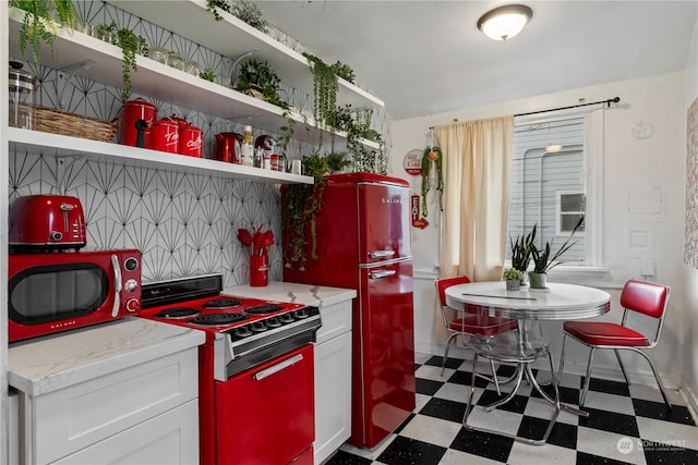 kitchen featuring white cabinets, refrigerator, stove, and backsplash