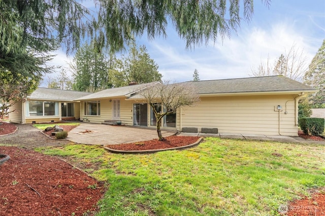 rear view of property with a patio, a yard, and a chimney