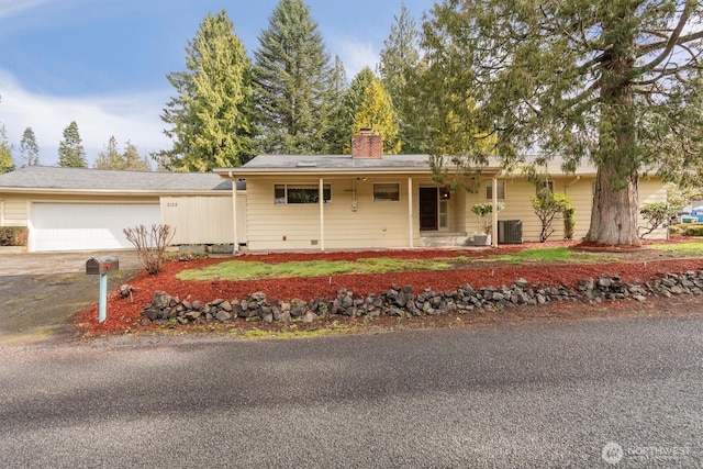 ranch-style house with crawl space, cooling unit, a chimney, and driveway