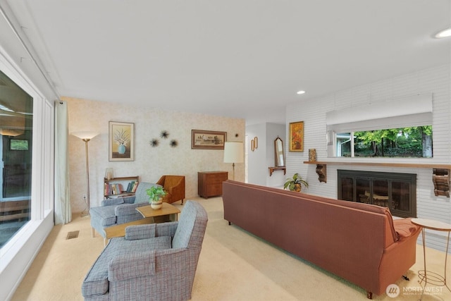 carpeted living room with recessed lighting, visible vents, and a fireplace