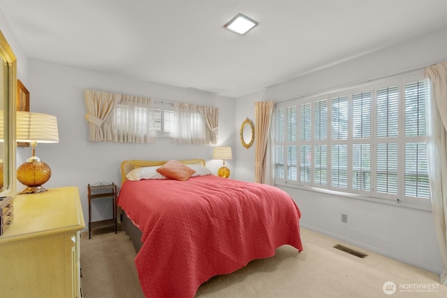 carpeted bedroom featuring visible vents and baseboards