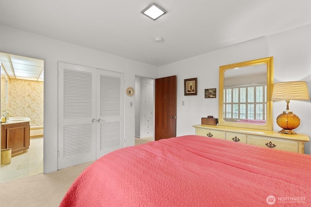 bedroom featuring a closet, light colored carpet, and wallpapered walls