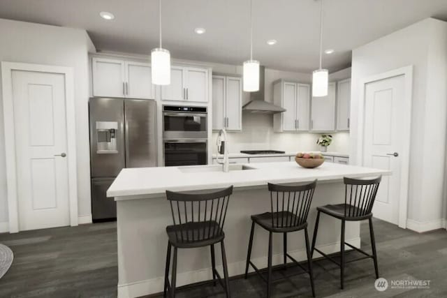 kitchen with stainless steel appliances, light countertops, a sink, an island with sink, and wall chimney exhaust hood