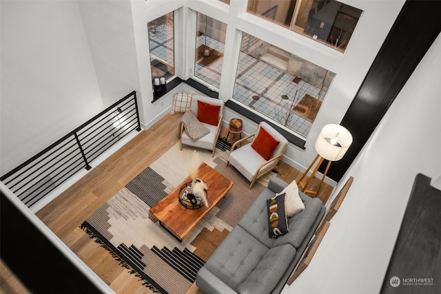 living room with hardwood / wood-style floors and a towering ceiling