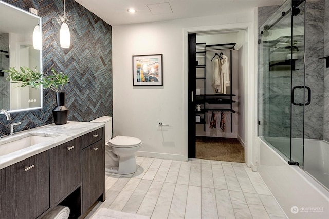 full bathroom featuring shower / bath combination with glass door, vanity, and toilet