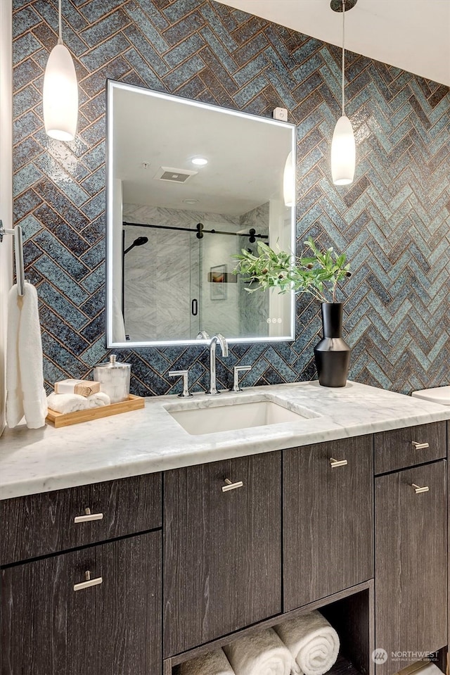 bathroom with vanity, tile walls, tasteful backsplash, and walk in shower