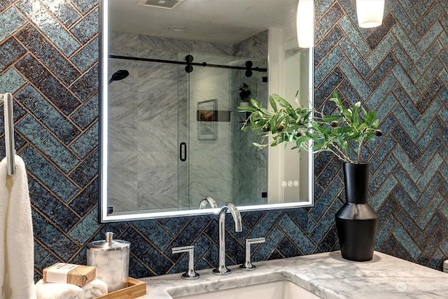 bathroom featuring backsplash, an enclosed shower, and vanity