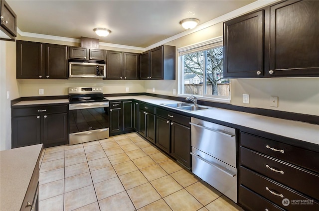 kitchen featuring dark brown cabinetry, sink, crown molding, light tile patterned floors, and appliances with stainless steel finishes