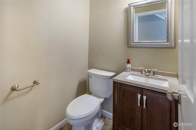 bathroom with tile patterned flooring, vanity, and toilet