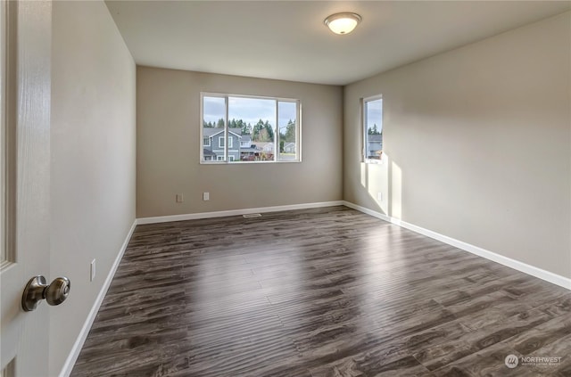 spare room with dark hardwood / wood-style flooring