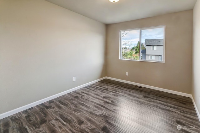 spare room featuring dark wood-type flooring