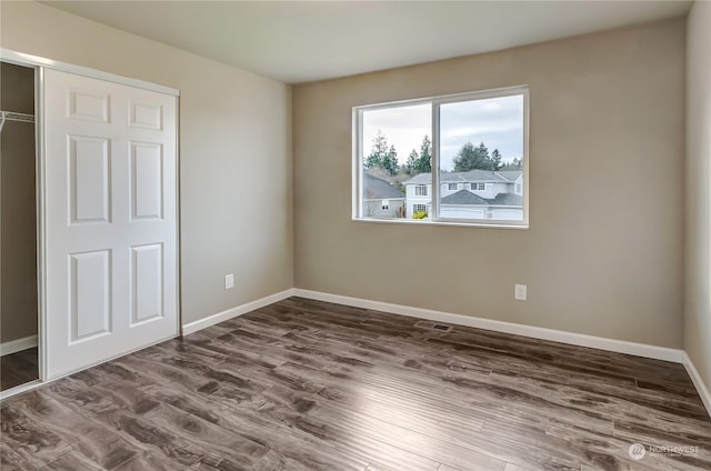 unfurnished bedroom featuring a closet and hardwood / wood-style flooring