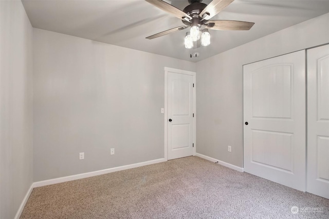 unfurnished bedroom with ceiling fan, light colored carpet, and a closet