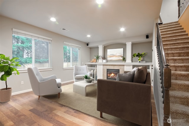 living room with hardwood / wood-style flooring and a tiled fireplace