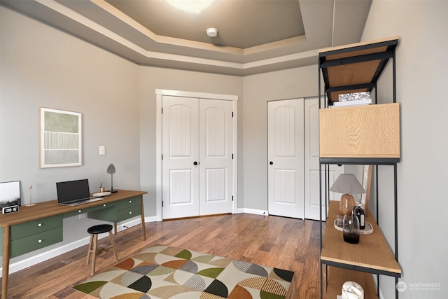 office featuring hardwood / wood-style floors and a raised ceiling