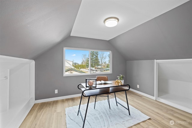 home office featuring light wood-type flooring and vaulted ceiling