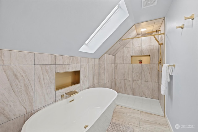 bathroom with separate shower and tub, tile patterned floors, tile walls, and vaulted ceiling with skylight