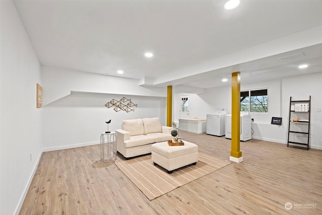 living room with light wood-type flooring and separate washer and dryer