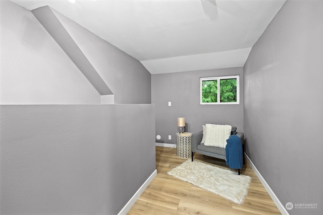 sitting room with light hardwood / wood-style floors and lofted ceiling