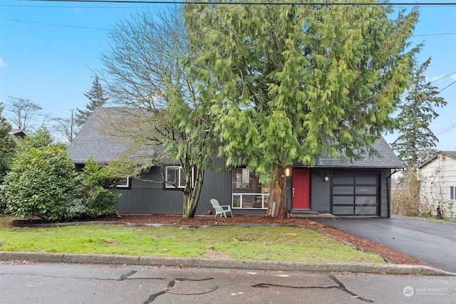 view of property hidden behind natural elements with a front lawn