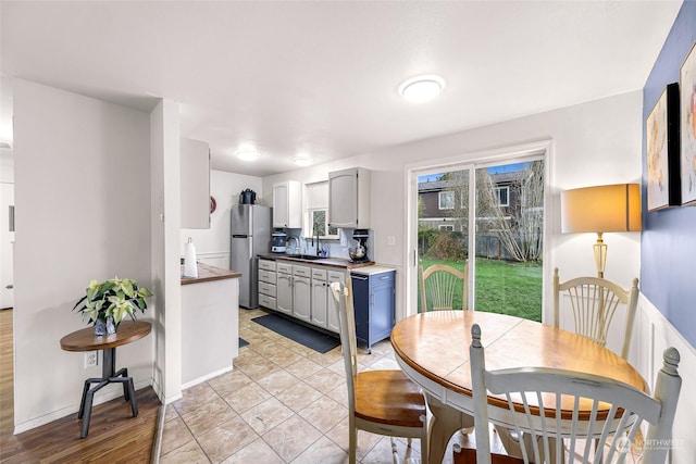 kitchen with stainless steel refrigerator, sink, and light wood-type flooring