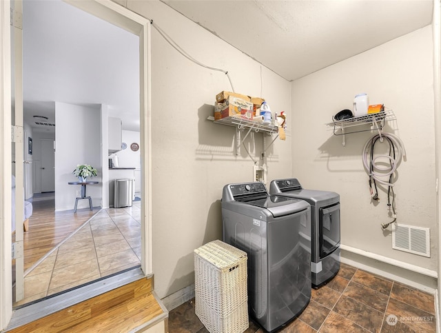 clothes washing area featuring dark hardwood / wood-style flooring and washing machine and dryer