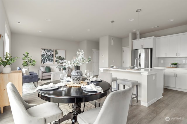 dining space featuring light hardwood / wood-style flooring and sink