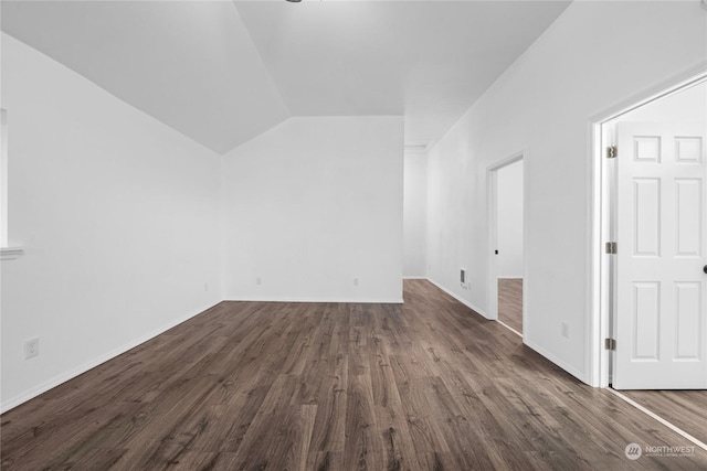 additional living space featuring dark hardwood / wood-style floors and lofted ceiling