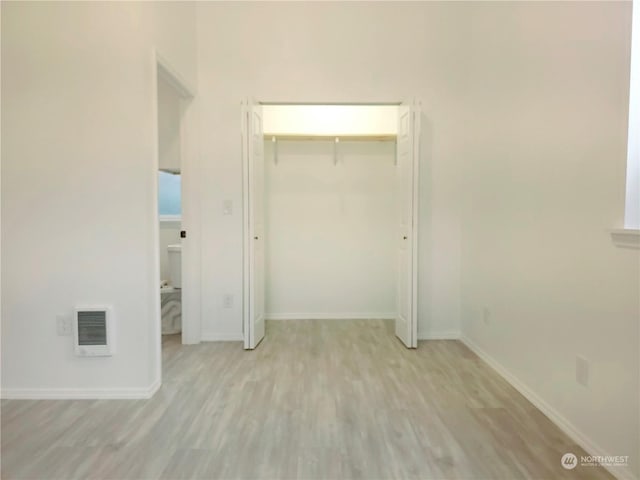 unfurnished bedroom with light wood-type flooring and a closet