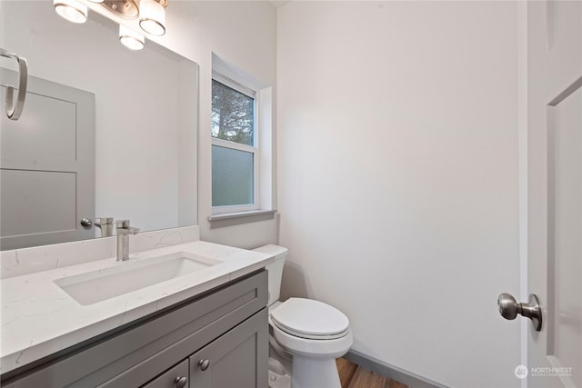 bathroom featuring hardwood / wood-style floors, vanity, and toilet