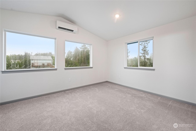 empty room with a wall mounted air conditioner, carpet floors, and lofted ceiling