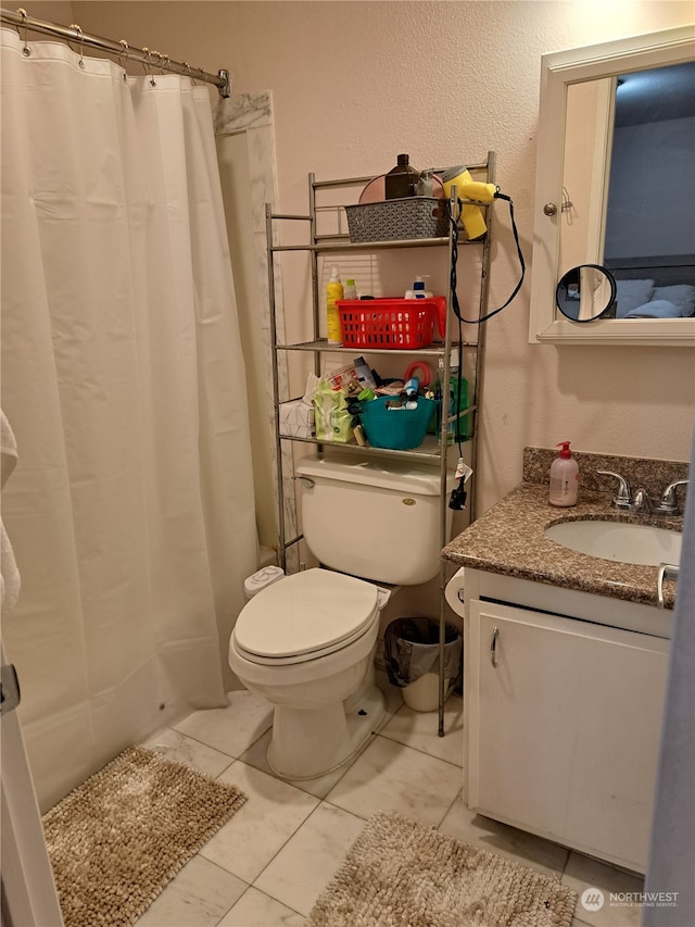 bathroom featuring tile patterned flooring, vanity, a shower with shower curtain, and toilet