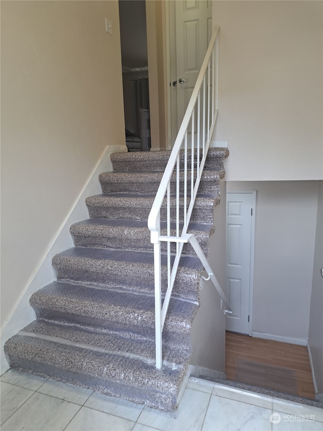 stairway featuring tile patterned flooring