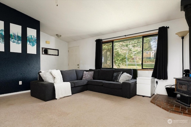 carpeted living room featuring a wood stove and lofted ceiling