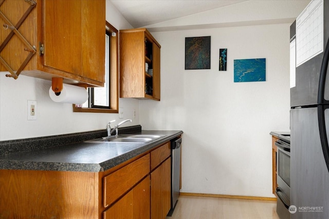 kitchen with light wood-type flooring, stainless steel appliances, vaulted ceiling, and sink