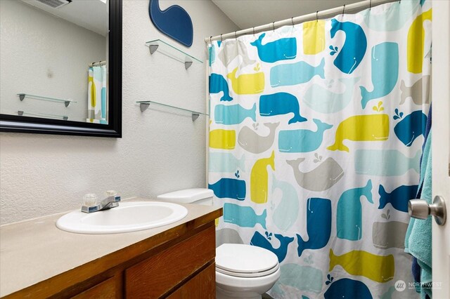 bathroom with a shower with curtain, vanity, and toilet